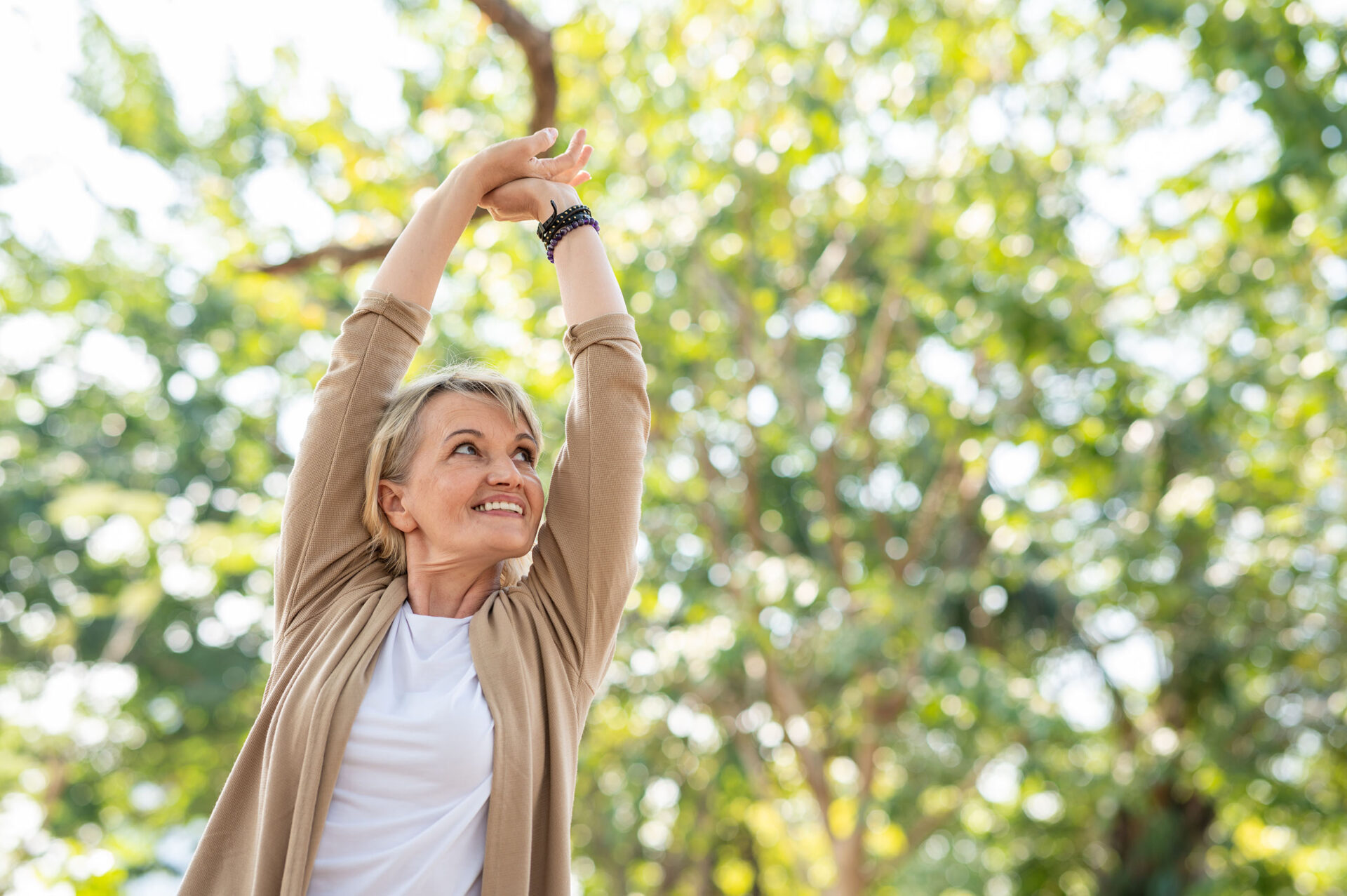 A woman, outdoors, enjoying the fresh air breathing easy after natural wellness therapies to relieve sinus pressure.