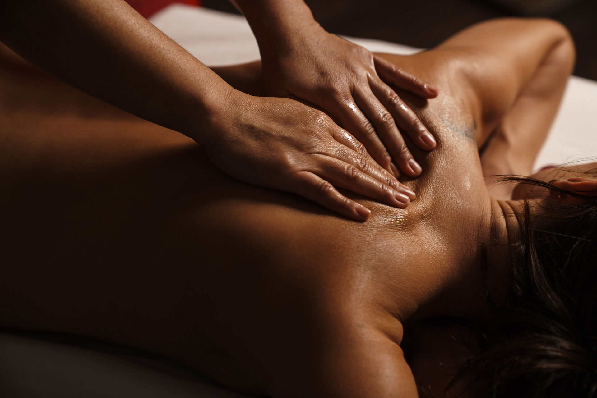 A close-up of a woman receiving a targeted massage before an infrared sauna session.
