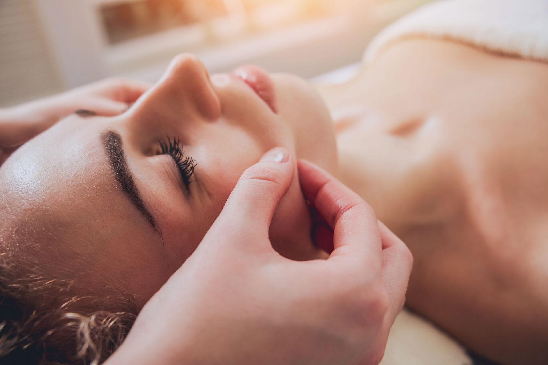 A close-up of a woman getting a professional facial treatment in a spa setting.