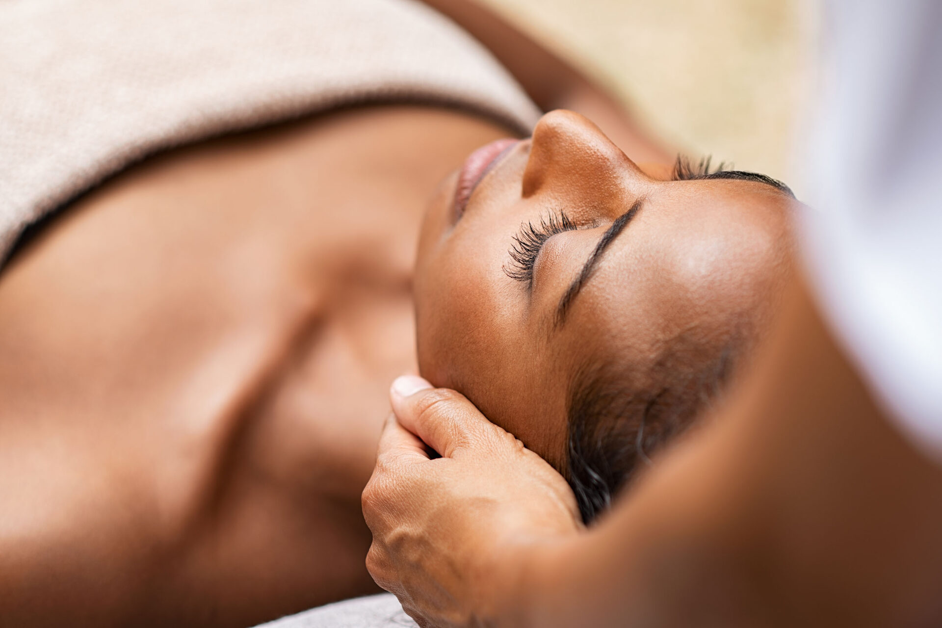 A close-up of a woman receiving a facial massage to compliment her at-home skin care routine.