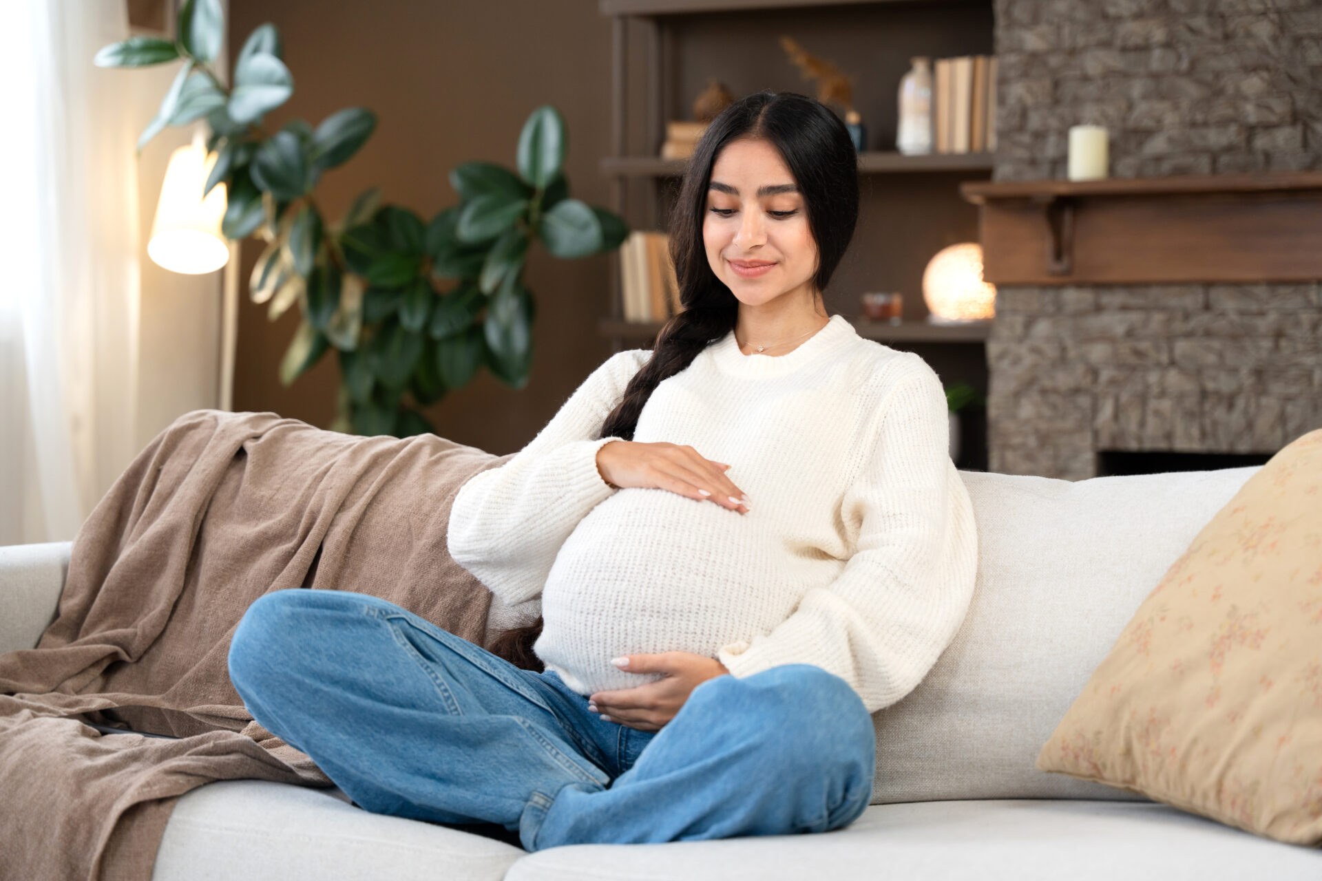 A beautiful mom to be relaxing on the couch after a prenatal massage.