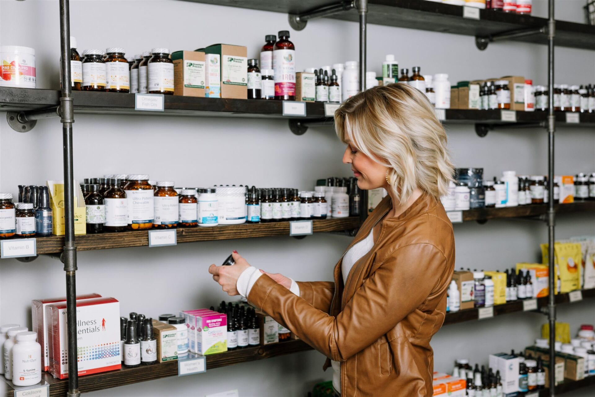 A woman shopping supplements at Tree of Life, excited to use her membership discounts in shop.